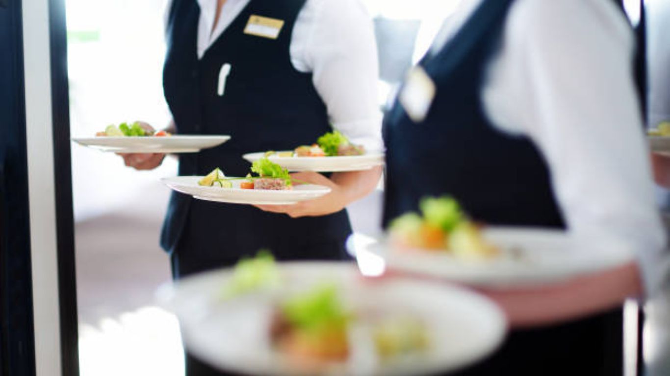 Servers carrying plated wedding dishes